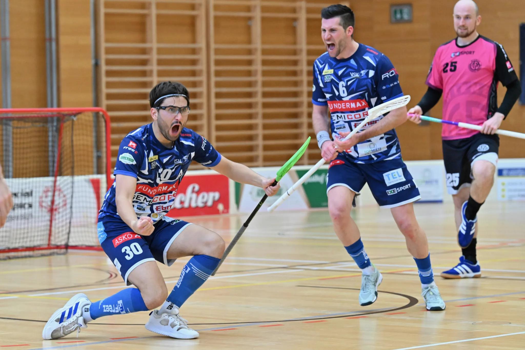 Zwei Spieler des VSV Unihockey jubeln nach einem Tor auf dem Hallenboden